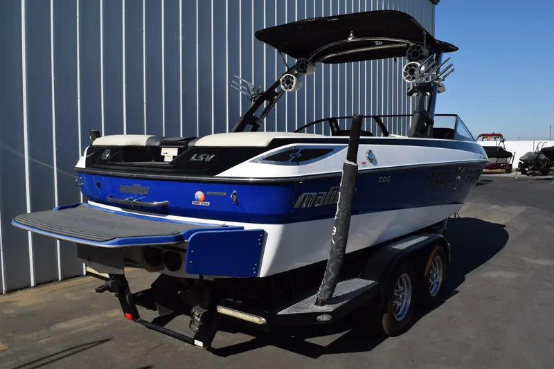 Slide: The Image of 2013 Malibu Wakesetter 23 LSV boat on trailer, blue and white exterior. - 2