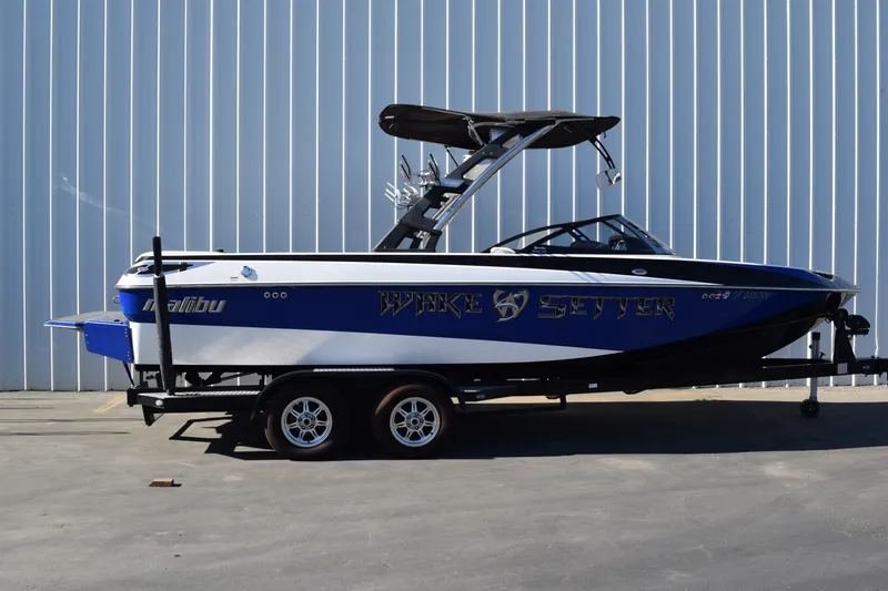 The Image of 2013 Malibu Wakesetter 23 LSV boat on trailer, blue and white design. - 0