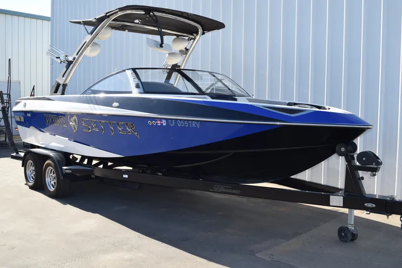 Slide: The Image of 2013 Malibu Wakesetter 23 LSV boat on trailer, blue and black design. - 1