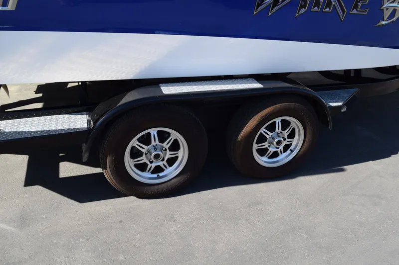 Slide: The Image of Trailer wheels of a 2013 Malibu Wakesetter 23 LSV boat on pavement. - 3