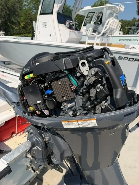 Slide: The Image of An outboard motor with its cover open, revealing internal mechanics and wiring. - 11