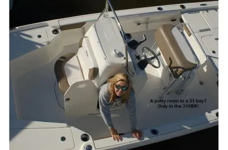 Slide: The Image of A woman leans over the side of a white boat with brown seats. - 2