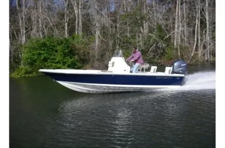 Slide: The Image of A blue and white boat speeds along a river, surrounded by trees. - 9