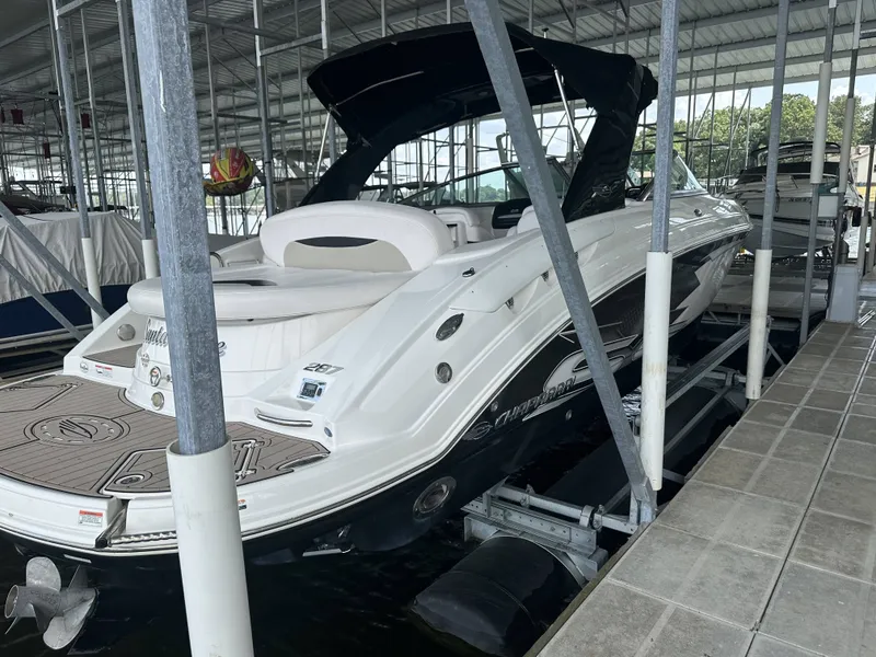 Slide: The Image of A white 2011 Chaparral 287 SSX boat is docked in a covered marina. - 2