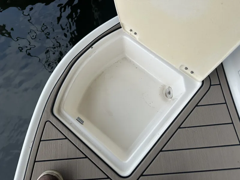 Slide: The Image of An open storage compartment on a boat with wood-patterned decking. - 6