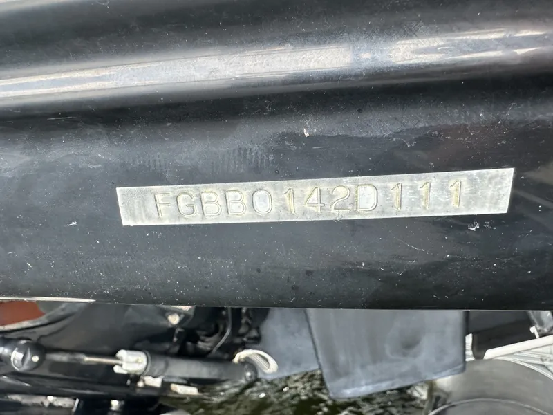 Slide: The Image of Close-up of the serial number on a black boat hull, with part of the engine visible below. - 34