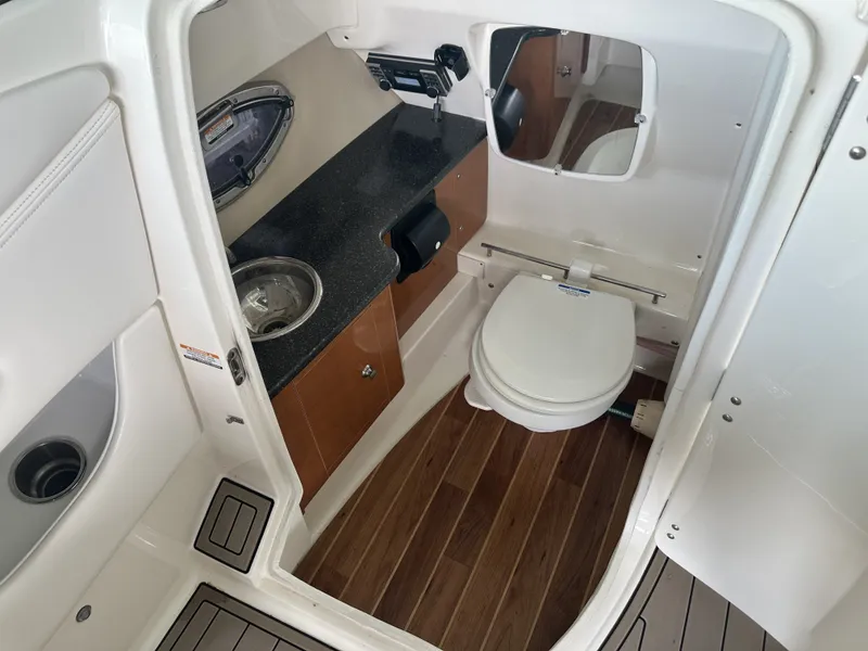 Slide: The Image of The image shows the bathroom of a 2011 Chaparral 287 SSX with a toilet and sink. - 18