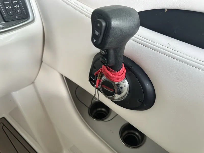 Slide: The Image of Close-up of a boat throttle lever with red cords, surrounded by white upholstery. - 26