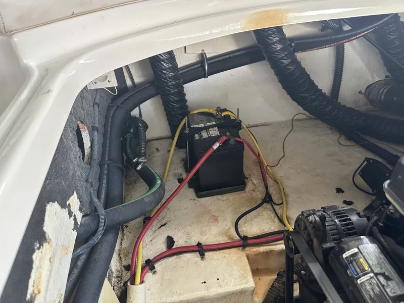 Slide: The Image of A boat's battery compartment with cables and a black battery. - 39