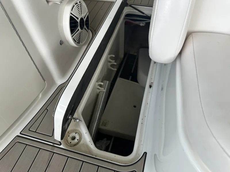 Slide: The Image of An open storage compartment on a boat with a speaker and seat cushion. - 16