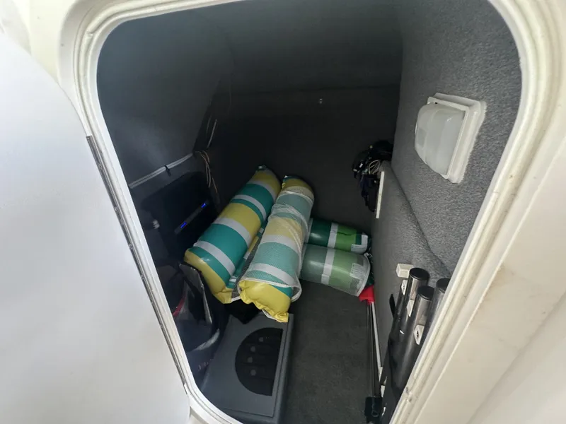 Slide: The Image of A storage compartment inside a boat with striped cushions and equipment. - 28