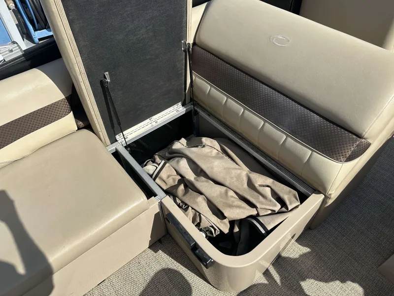 Slide: The Image of An open storage compartment on a boat with beige upholstery and a cover inside. - 10