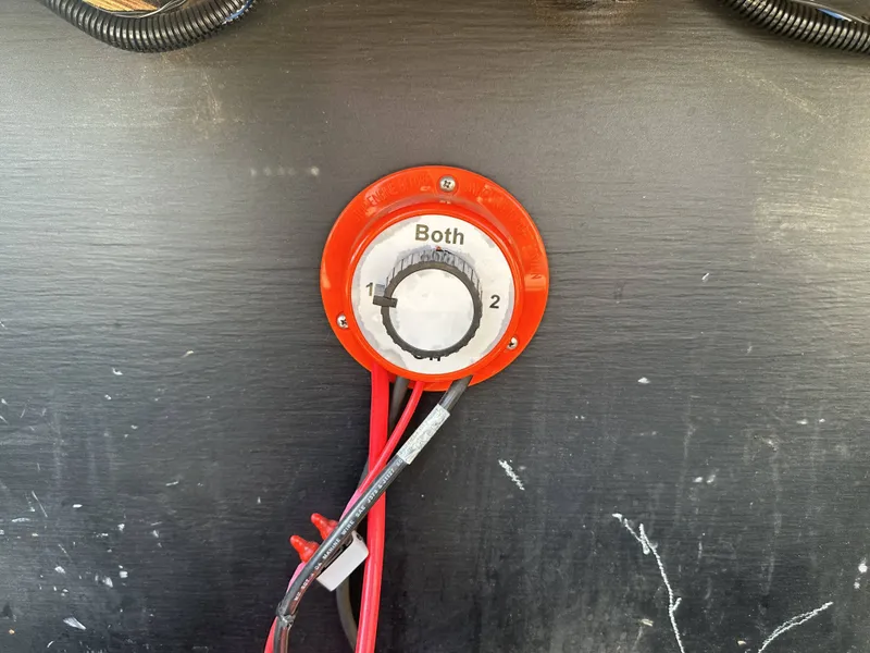 Slide: The Image of A red battery switch with settings "1," "2," and "Both" is mounted on a wall. - 13