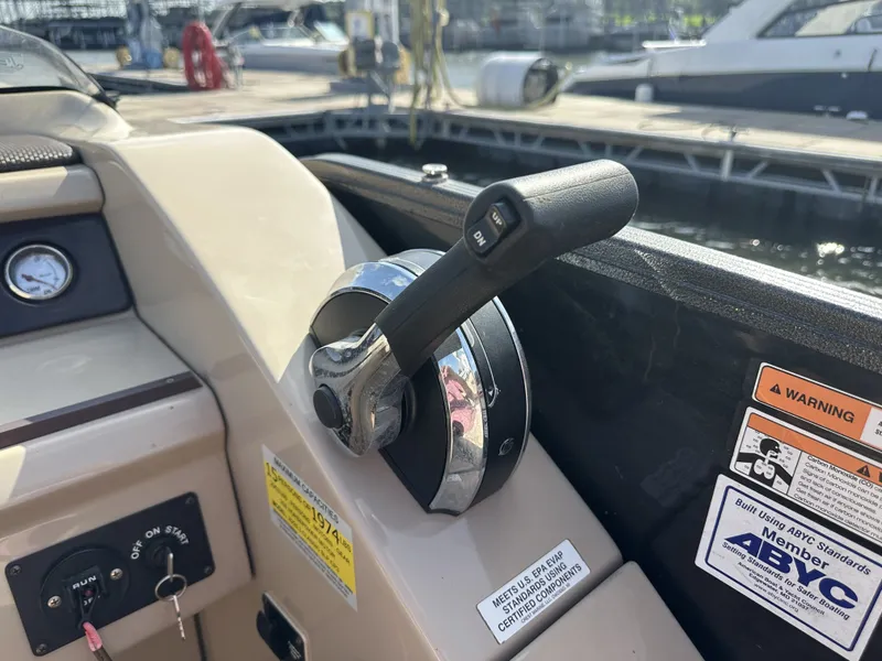 Slide: The Image of Close-up of a throttle lever on a boat, surrounded by warning labels and a dock in the background. - 23
