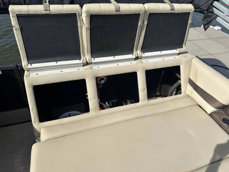 Slide: The Image of The back of a boat seat with open storage compartments, situated on a dock. - 12