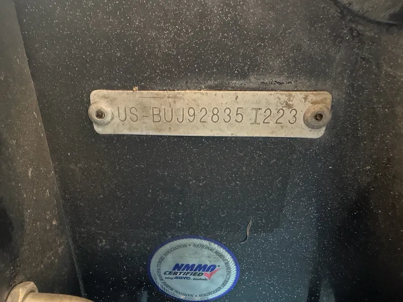 Slide: The Image of Close-up of a serial number on a boat with a certification seal below. - 32