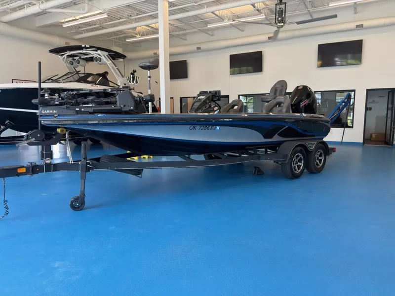The Image of A 2023 Nitro Z20 boat sits on a trailer in a showroom with a blue floor. - 1