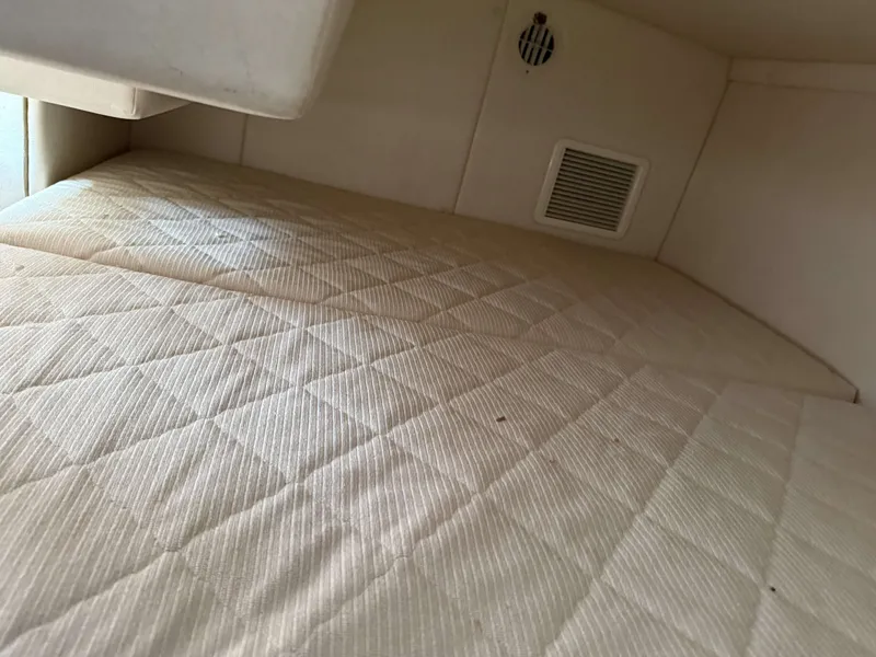 Slide: The Image of Interior of a 2007 Sea Ray 240 Sundancer with a cushioned sleeping area and ventilation. - 14