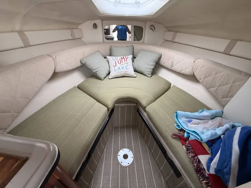 Slide: The Image of The cabin of a 2007 Sea Ray 240 Sundancer features a cozy bed with cushions. - 17