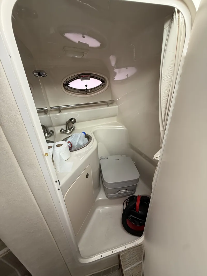 Slide: The Image of The image shows a small boat bathroom with a sink, toilet, and porthole. - 16