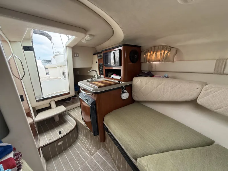 Slide: The Image of Interior of a 2007 Sea Ray 240 Sundancer featuring a kitchenette and seating area. - 18
