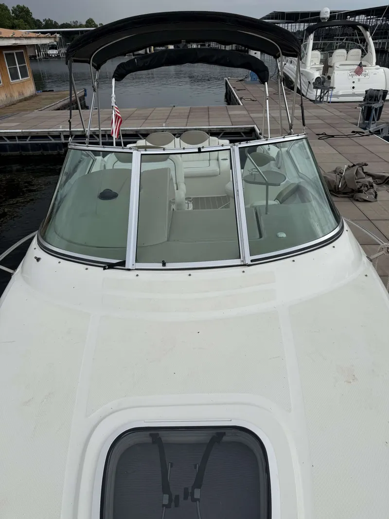 Slide: The Image of A 2007 Sea Ray 240 Sundancer docked. It features a black canopy and spacious cabin. - 3