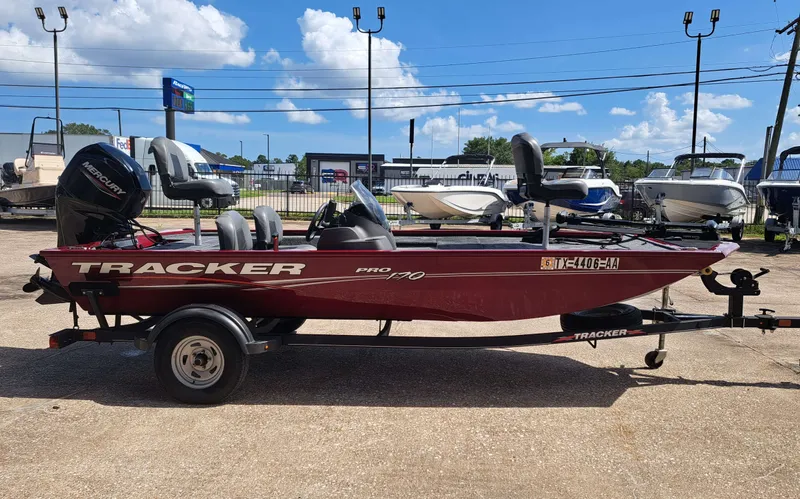 Slide: The Image of A red 2022 Tracker Pro 170 boat sits on a trailer in an outdoor area. - 5