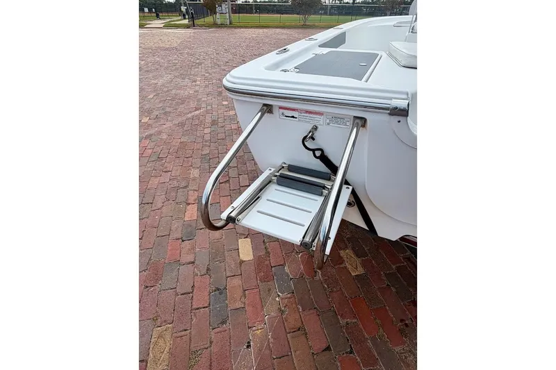Slide: The Image of 2016 Sportsman Island Bay 20 boat with foldable swim ladder on brick pavement. - 14