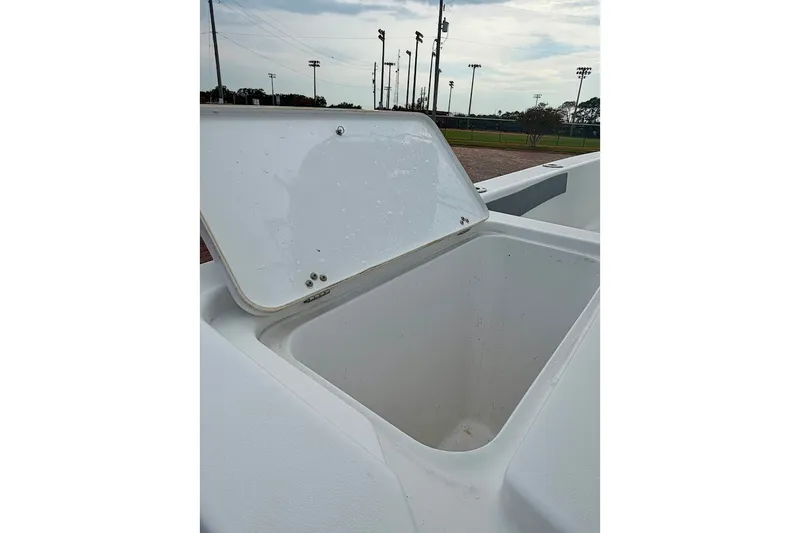 Slide: The Image of Open storage compartment on a 2016 Sportsman Island Bay 20 boat, outdoor setting. - 19