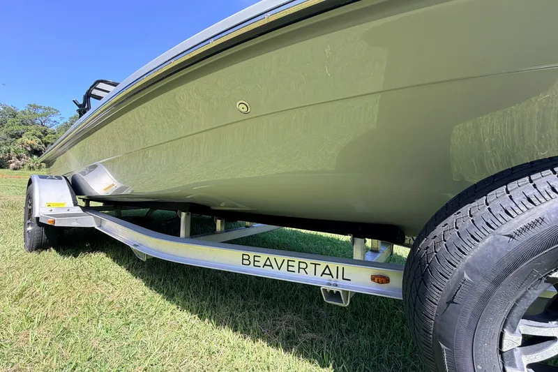 Slide: The Image of 2019 Beavertail Skiffs Vengeance 18' boat on trailer, side view on grass. - 11