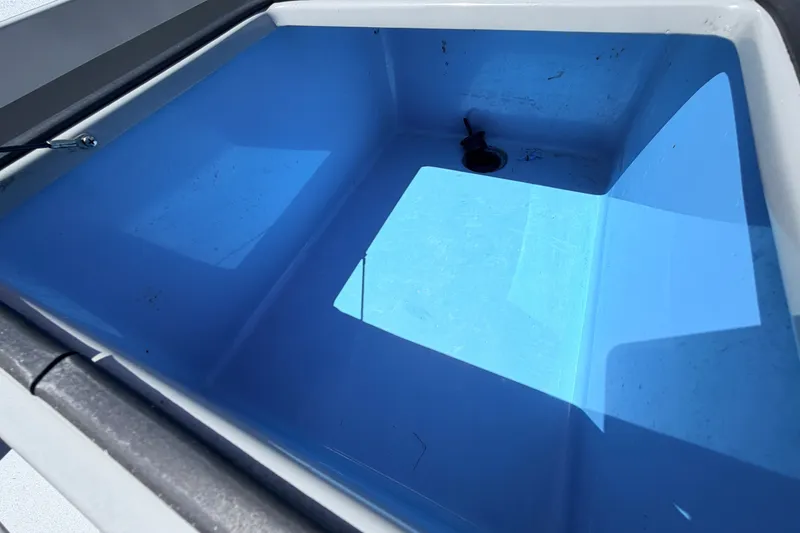 Slide: The Image of 2019 Beavertail Skiffs Vengeance 18' livewell interior, featuring a blue finish and drain plug. - 35