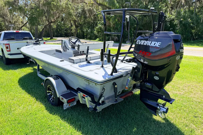 Slide: The Image of 2019 Beavertail Skiffs Vengeance 18' boat with Evinrude motor on trailer, parked on grass. - 5