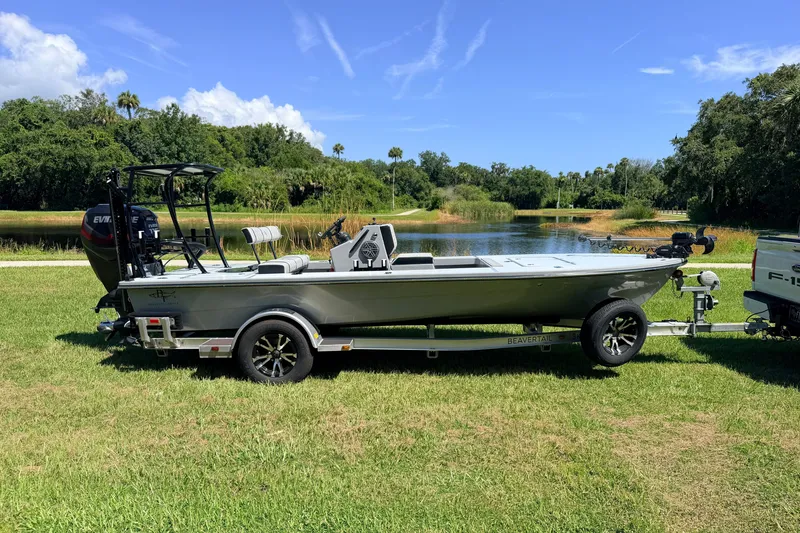 Slide: The Image of 2019 Beavertail Skiffs Vengeance 18' boat on trailer by a scenic lake. - 2
