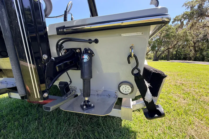 Slide: The Image of 2019 Beavertail Skiffs Vengeance 18' boat transom with hydraulic components and lush green background. - 15