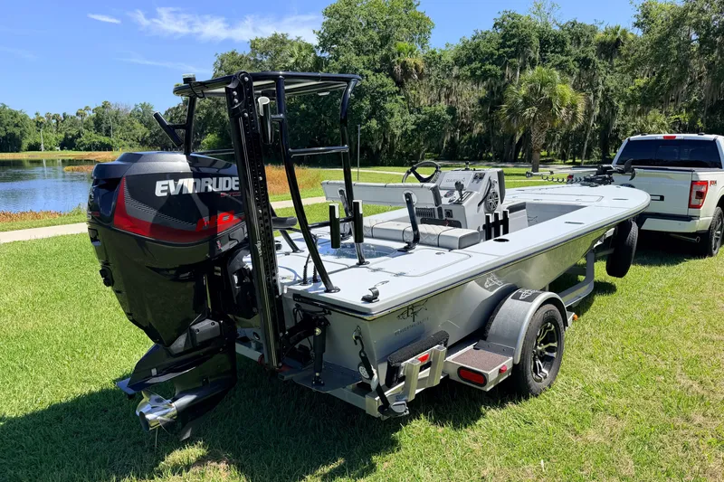 Slide: The Image of 2019 Beavertail Skiffs Vengeance 18' boat with Evinrude motor on trailer by a lake. - 3