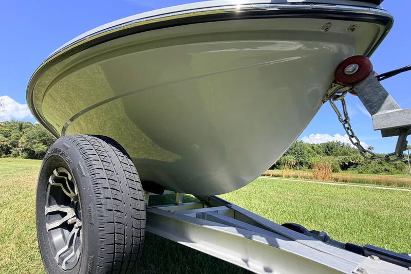 Slide: The Image of 2019 Beavertail Skiffs Vengeance 18' boat on trailer, grassy landscape background. - 10
