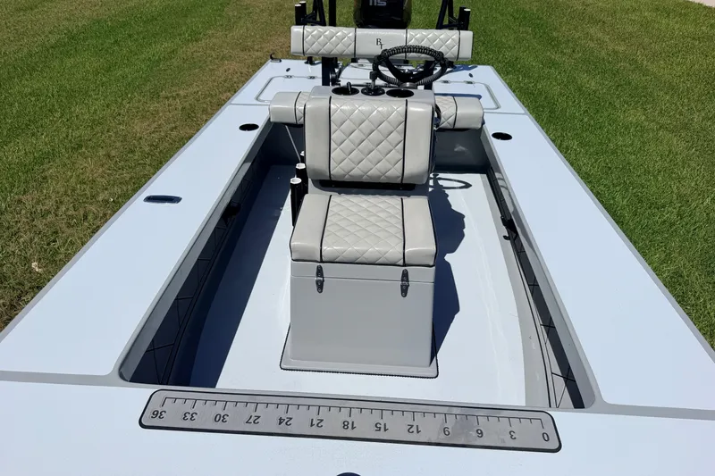 Slide: The Image of 2019 Beavertail Skiffs Vengeance 18' boat with quilted seating on grass. - 30