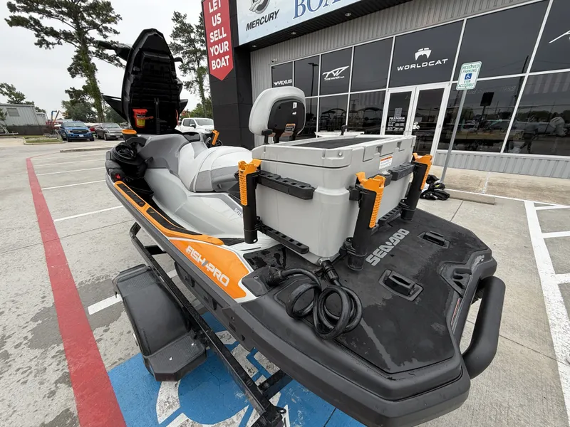 Slide: The Image of A 2022 Sea-Doo FISH PRO TROPHY 170 on a trailer outside a boat dealership. It features a cooler and fishing rod holders. - 11