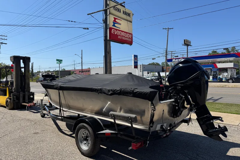 The Image of 2020 Alumacraft Summit 165 boat on trailer, covered, near Parma Marine sign. - 0