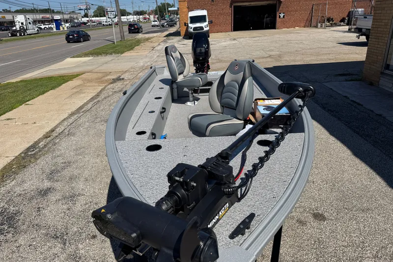 Slide: The Image of 2020 Alumacraft Summit 165 boat with seating and motor, parked on a street. - 15