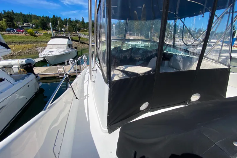 Slide: The Image of 2003 Carver 350 Mariner yacht docked at marina, featuring enclosed cockpit and scenic background. - 25