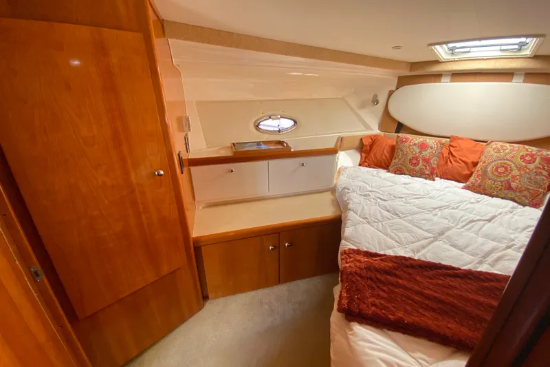 Slide: The Image of Cozy cabin interior of 2003 Carver 350 Mariner with bed, wood cabinetry, and porthole window. - 17