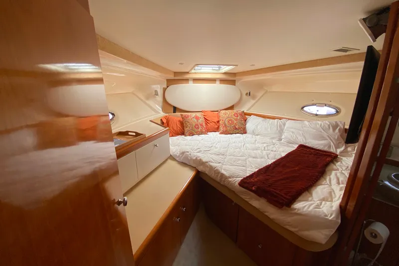 Slide: The Image of Cozy cabin interior of 2003 Carver 350 Mariner yacht with plush bedding and wood cabinetry. - 16