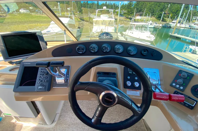 Slide: The Image of Helm of 2003 Carver 350 Mariner yacht with steering wheel and navigation controls. - 34
