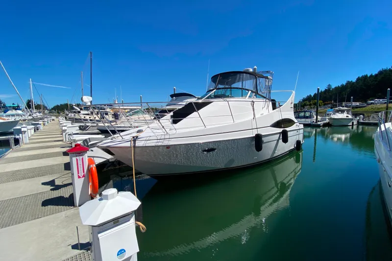 The Image of 2003 Carver 350 Mariner yacht docked at a marina under clear blue skies. - 0