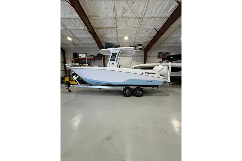 The Image of 2026 Wellcraft 243 Fisherman boat on trailer in indoor storage facility. - 0