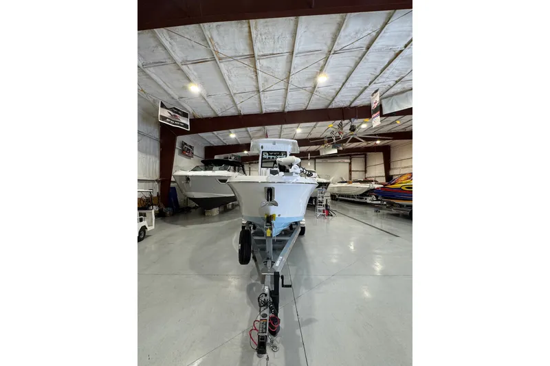 Slide: The Image of 2026 Wellcraft 243 Fisherman boat in a spacious indoor showroom. - 2