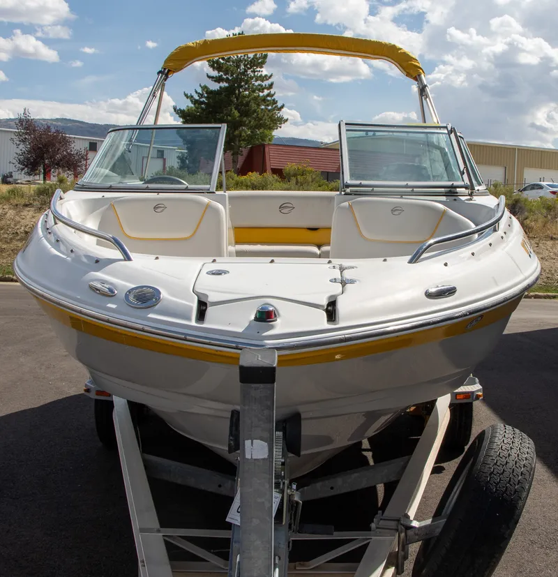 Slide: The Image of A 2008 Crownline 210 LS boat on a trailer, featuring a yellow sunshade and clear windows. - 8