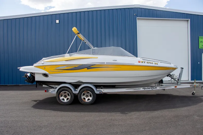 Slide: The Image of A 2008 Crownline 210 LS boat on a trailer in front of a blue building. - 7