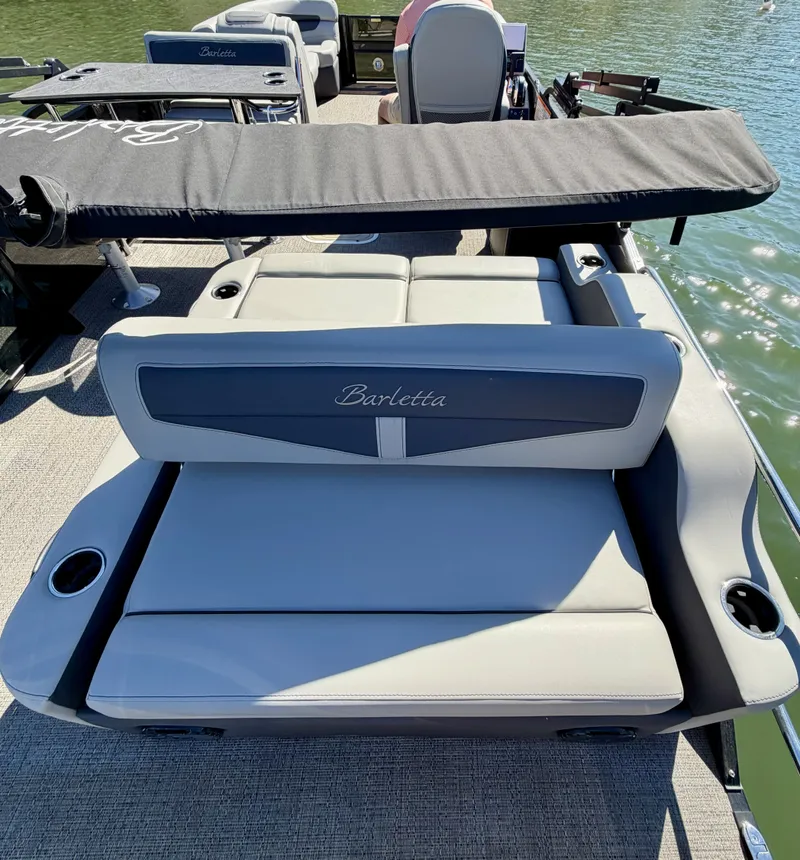Slide: The Image of The image shows the rear of a Barletta Cabrio 24 UE pontoon boat with gray upholstery and cup holders. - 11